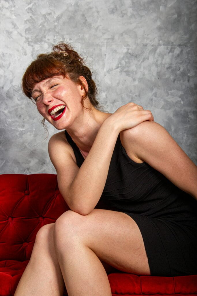 Young white woman sitting and laughing